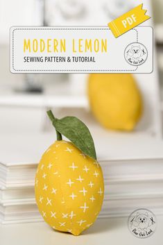 an orange sitting on top of a table next to a book with the title modern lemon sewing pattern and video