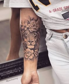 a woman with a lion and flowers tattoo on her arm