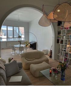 a living room filled with furniture and lots of bookshelves on top of a hard wood floor