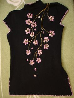 a black sweater with pink flowers on it