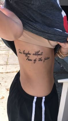 the back of a woman's stomach with an inscription on it that says, she laughs