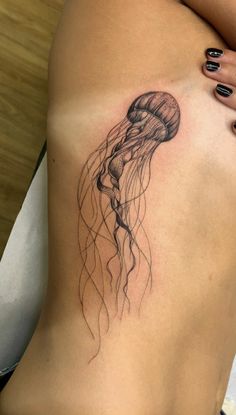 a woman's stomach with a jellyfish tattoo on it