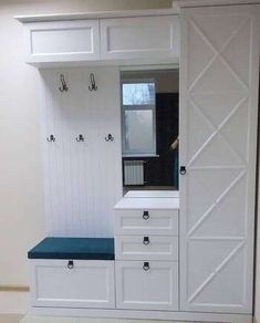 an empty room with white cabinets and blue cushion on the bench in front of it