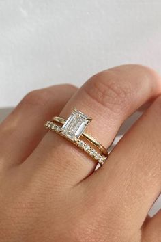 a woman's hand with a gold ring and diamond band on her left wrist