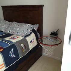 a bed with a basketball hoop on the headboard next to pillows and a pillow