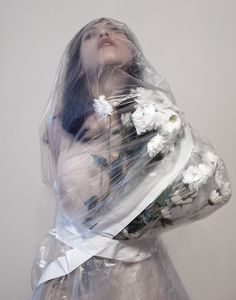 a woman wrapped in plastic holding flowers