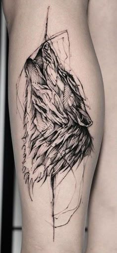 a black and white photo of a wolf tattoo on the right thigh, with an arrow in it