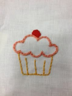 embroidered cupcake on white linen with red thread