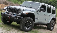 a gray jeep parked on top of a dirt road