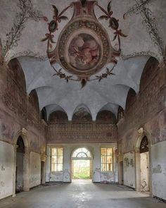 an empty room with paintings on the ceiling