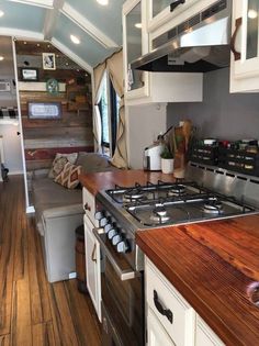 a kitchen with an oven, stove and sink inside of it on a wooden floor