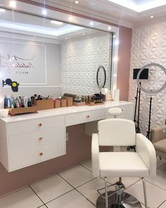 a white chair sitting in front of a mirror on top of a counter next to a hair dryer