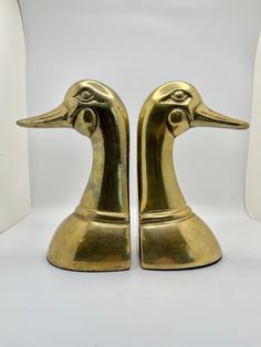 two brass ducks are standing next to each other