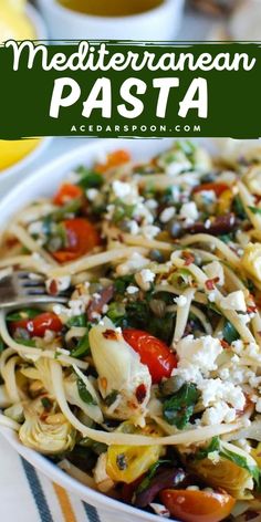 a white bowl filled with pasta and veggies on top of a striped table cloth