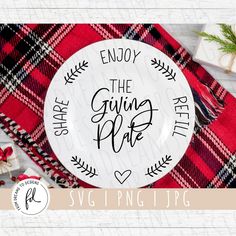 a white plate with the words enjoy the giving plate on it next to christmas decorations