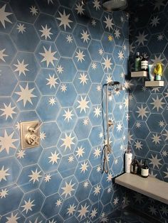 a bathroom with blue and white stars painted on the wall, shower head, and sink