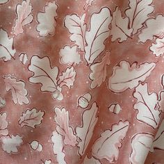 the fabric has pink and white leaves on it