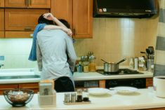 two people in a kitchen hugging each other