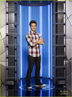 a man standing in front of a blue and white background with his arms crossed,