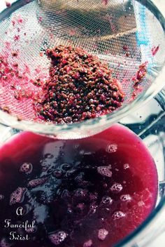 a blender filled with red liquid sitting on top of a counter