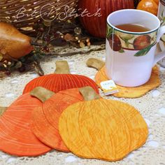 there is a cup of tea next to some pumpkins