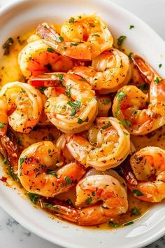 a white bowl filled with cooked shrimp and garnished with parsley