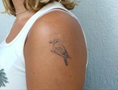 a woman with a small bird tattoo on her left upper arm and right lower arm