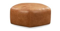 a brown leather ottoman sitting on top of a white floor