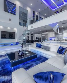 a living room with white couches and blue lighting on the ceiling is pictured in this image