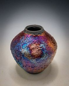 a colorful vase sitting on top of a white table