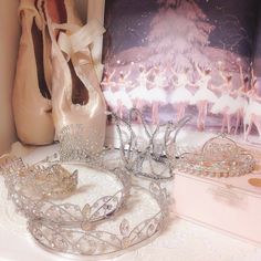 some tiaras are sitting on a table next to a vase and other items in front of a painting