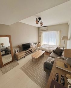 a living room filled with furniture and a flat screen tv on top of a wooden table