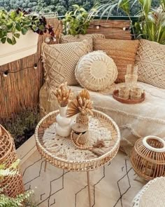 an outdoor seating area with wicker furniture and potted plants on the side table