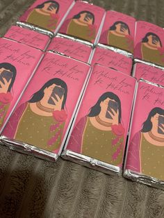 six pink lighters with pictures of women on them, all wrapped in tin foil