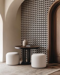 two white stools sitting next to a table on top of a carpeted floor