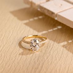 a diamond ring sitting on top of a piece of paper next to a wooden bench