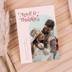 a wedding thank card with the words love and thanks on it next to a feather