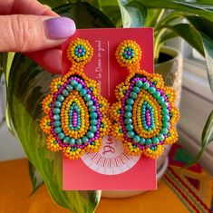 Our Monogem Earrings are a bold a fun statement to add to your fit! These colorful beaded earrings are handcrafted by our artisans in the heart of Mexico Lindo. Vibrant Colorful Earrings For Gifts, Artisan Multicolor Beaded Earrings For Gift, Unique Multicolor Large Beads Earrings, Unique Handmade Multicolor Teardrop Earrings, Unique Multicolor Earrings With Large Beads, Multicolor Teardrop Jewelry For Crafting, Bold Handmade Multicolor Earrings, Handmade Yellow Bohemian Teardrop Earrings, Multicolor Beaded Drop Earrings For Pierced Ears