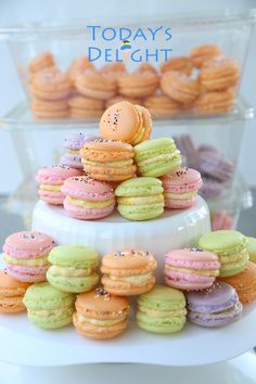 there is a three tiered cake with macaroons on it