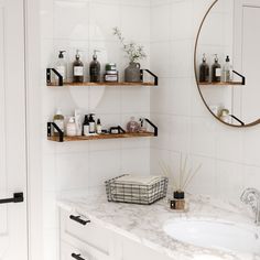 a bathroom with white tile and shelves filled with personal care items on the counter top