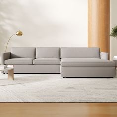 a living room with a couch, coffee table and lamp on the floor in front of it