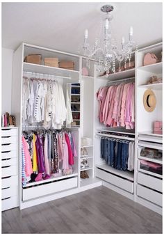 an organized closet with clothes, shoes and other items on shelves in the center is a chandelier