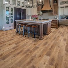 a large kitchen with wooden floors and an island