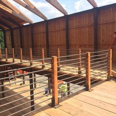 a wooden deck with metal railings and wood slats on the top part of it