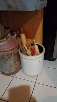 a bucket filled with wooden dows next to a fire hydrant on the floor