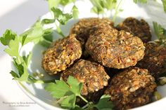 a white bowl filled with carrot patties and parsley sprinkled on top