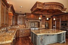 a large kitchen with wooden cabinets and marble counter tops