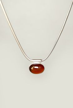 Handmade solid sterling silver necklace featuring a hessonite garnet pendant. The necklace consists of a snake chain with a clasp and a smooth garnet pendant. The oval translucent cinnamon red garnet cabochon is bezel set and glides freely along the chain. The pendant cannot be removed from the necklace.  Length: 40cm Chain width: 1.9mm Hessonite garnet: 14mm, app. 7cts, cinnamon red, ethically sourced, origin: Central African Republic We can make this necklace shorter or longer. For any modific Garnet Necklace Silver, Red Pendant Necklace, Cinnamon Red, Central African Republic, Product Shots, Red Pendants, Snake Chain Necklace, Hessonite Garnet, Garnet Pendant