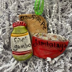 an ornament with two jars and a bowl on top of shredded up paper