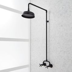 a black shower head and arm in a bathroom